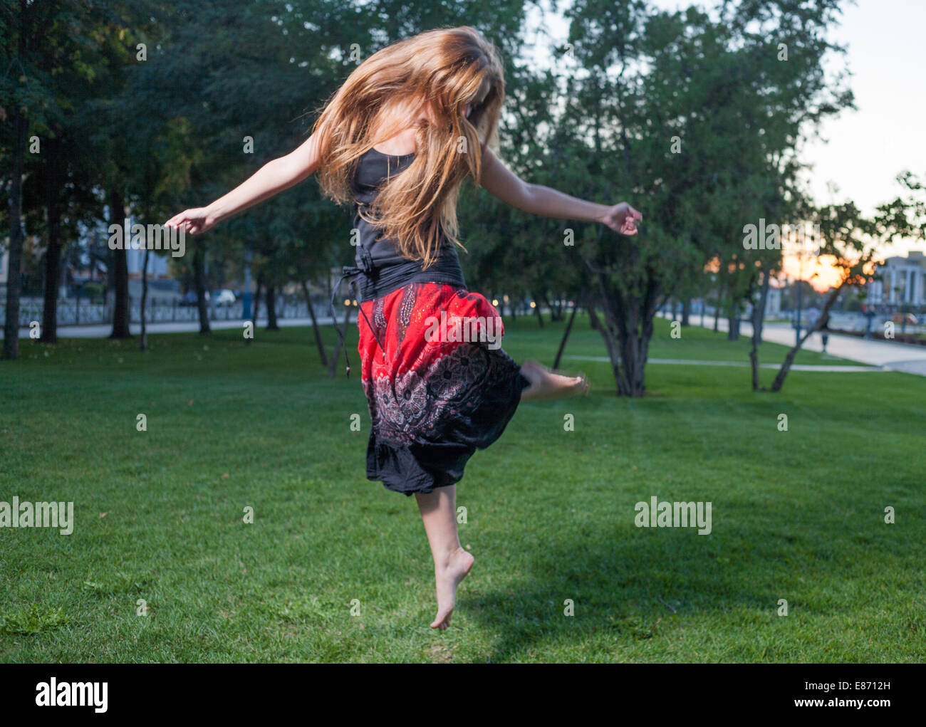 Long haired free style dancer. Girl jumping like flying bird. Stock Photo