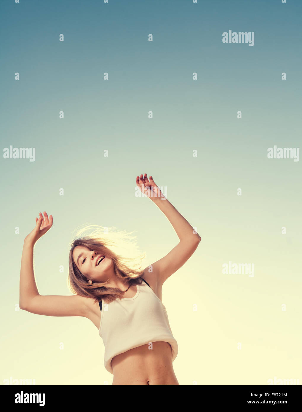 Happy female jumping with the blue sky in the background Stock Photo ...