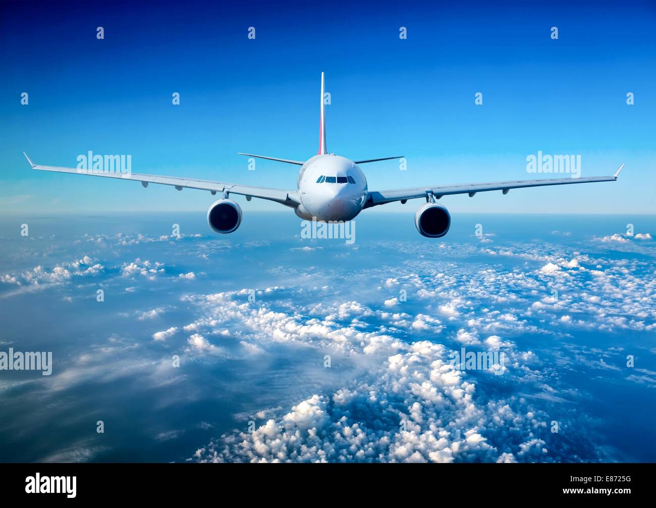Passenger Airliner flying in the clouds Stock Photo - Alamy