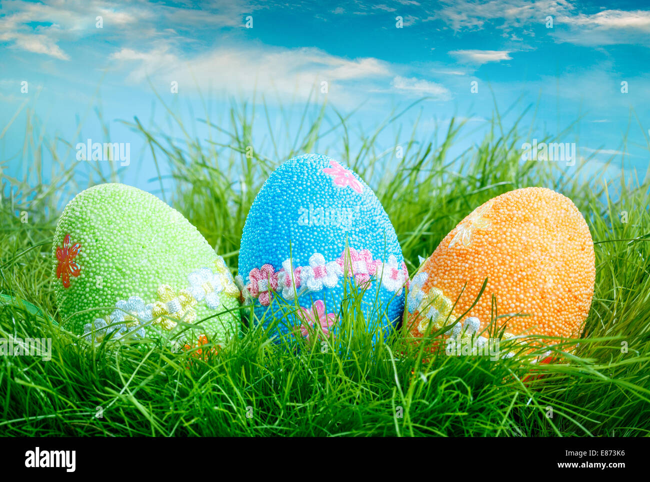 Decorated easter eggs in the grass on blue sky background Stock Photo ...