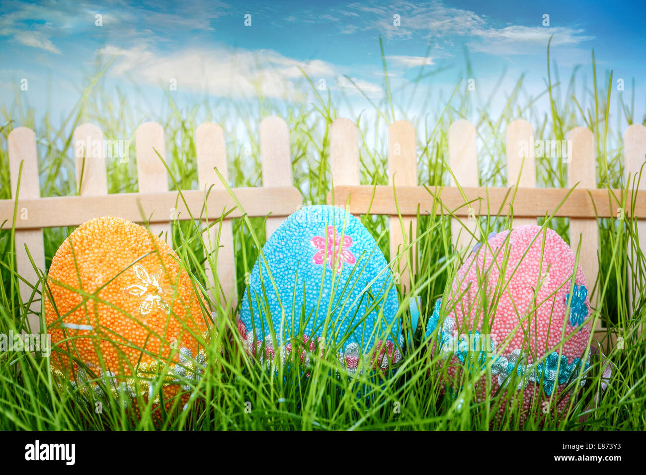 Decorated easter eggs in the grass on blue sky background Stock Photo ...