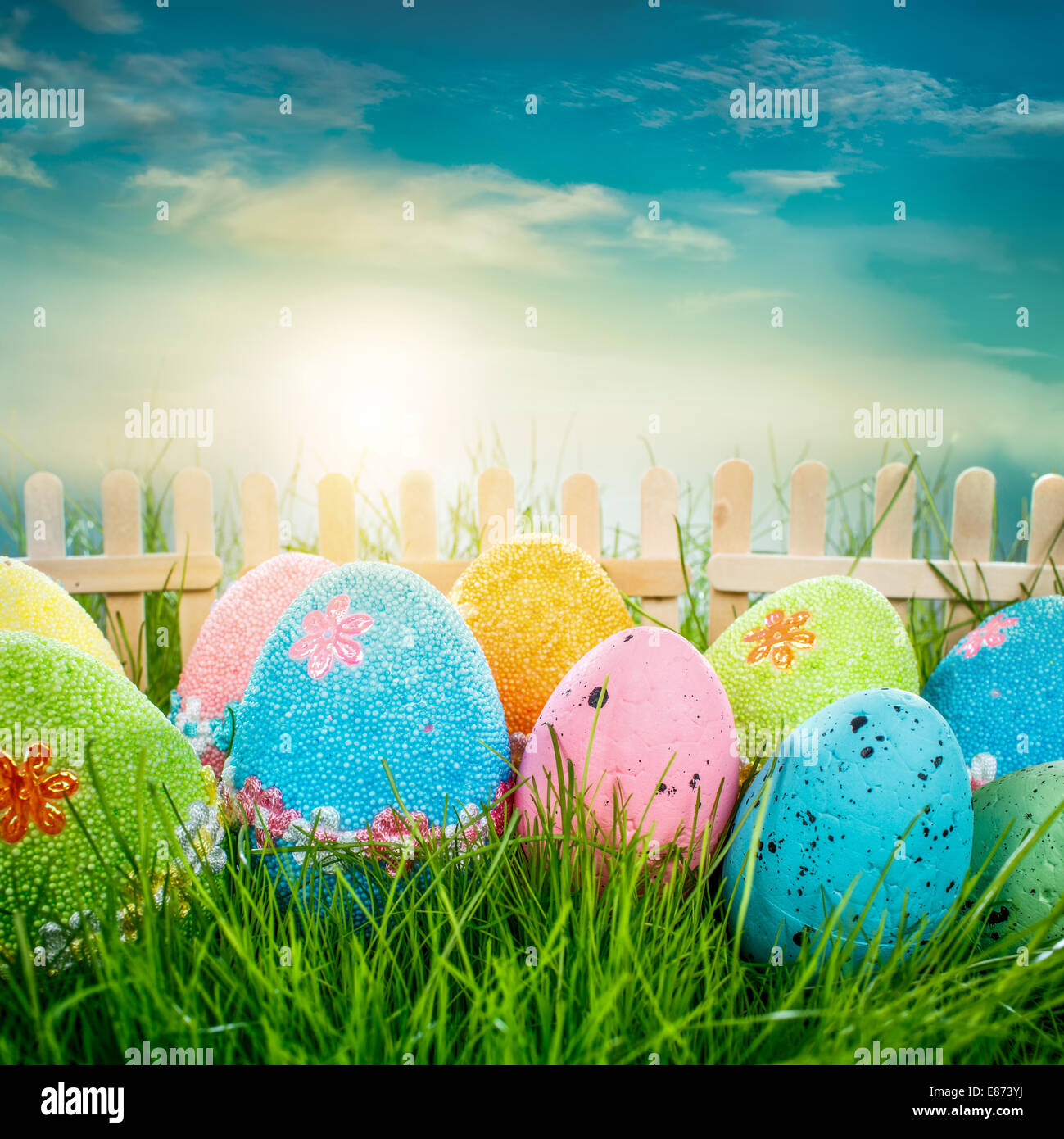 Decorated easter eggs in the grass on blue sky background Stock Photo ...
