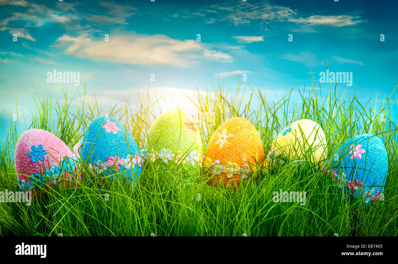 Decorated easter eggs in the grass on blue sky background Stock Photo