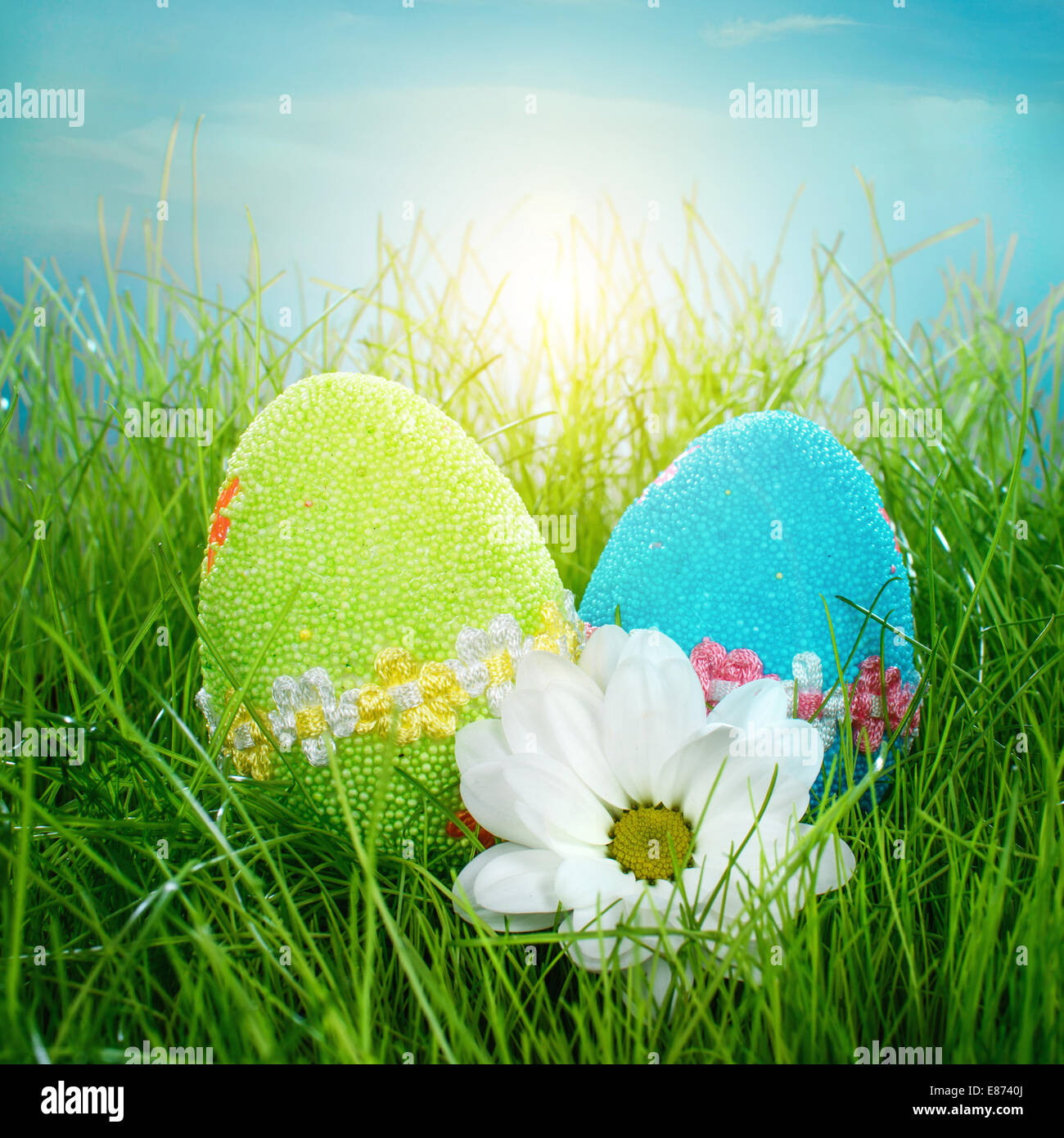 Decorated easter eggs in the grass on blue sky background Stock Photo ...