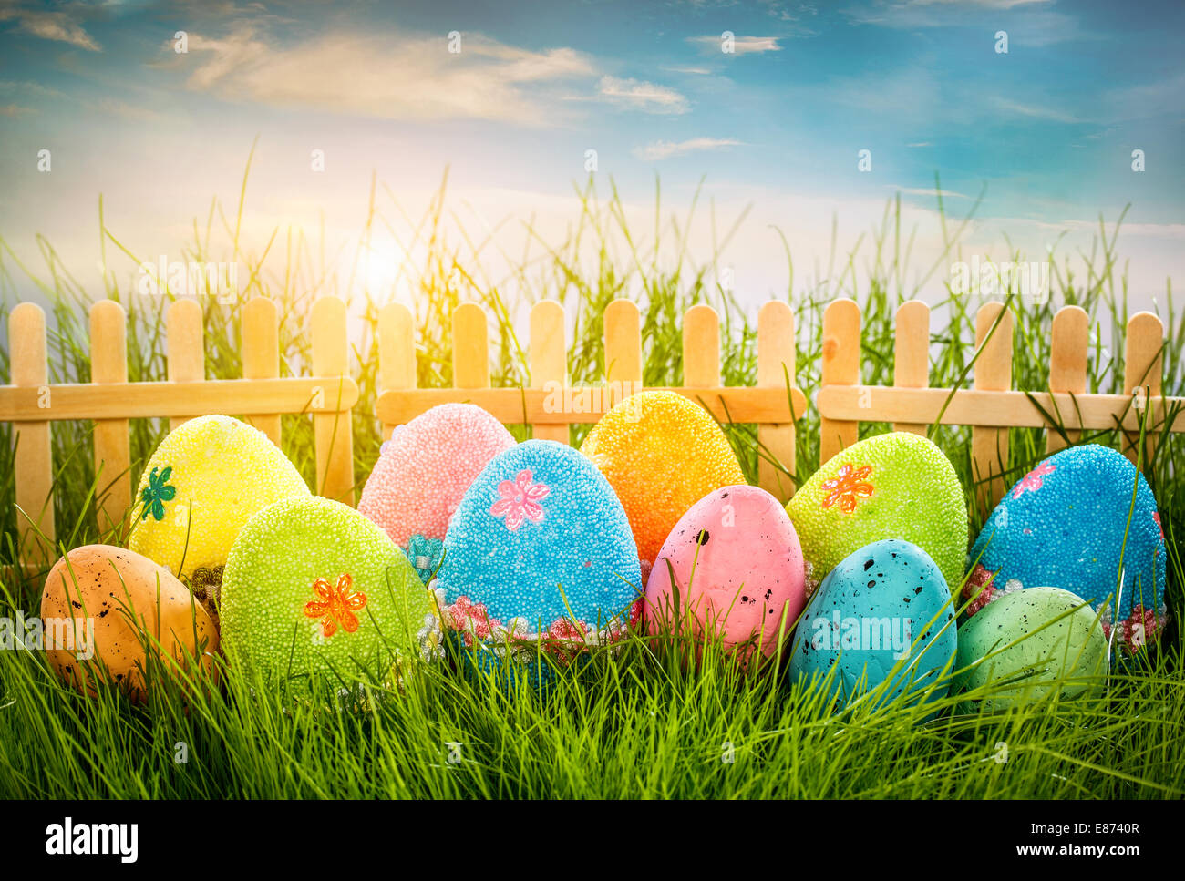 Decorated easter eggs in the grass on blue sky background Stock Photo ...