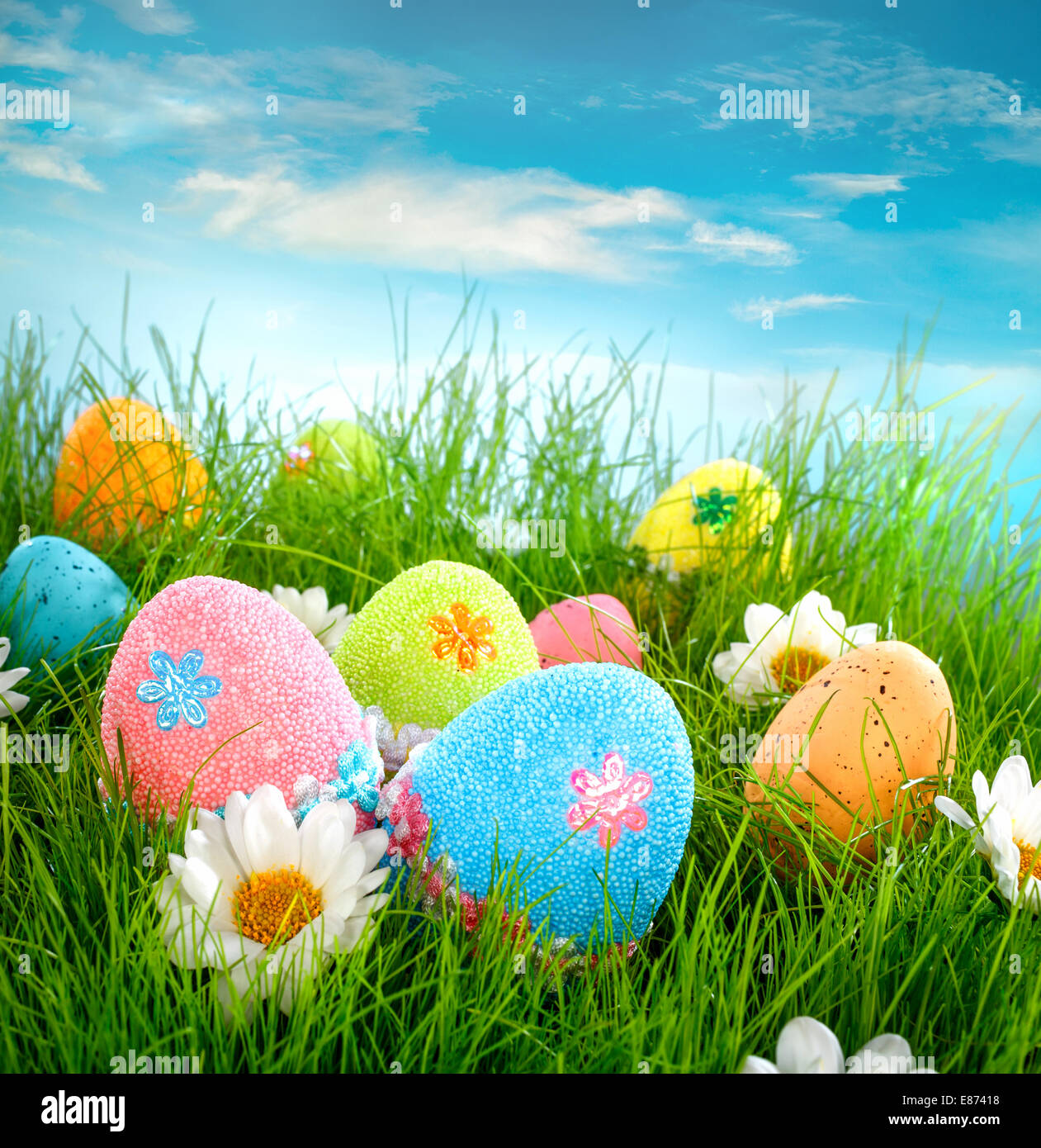 Decorated easter eggs in the grass on blue sky background Stock Photo ...