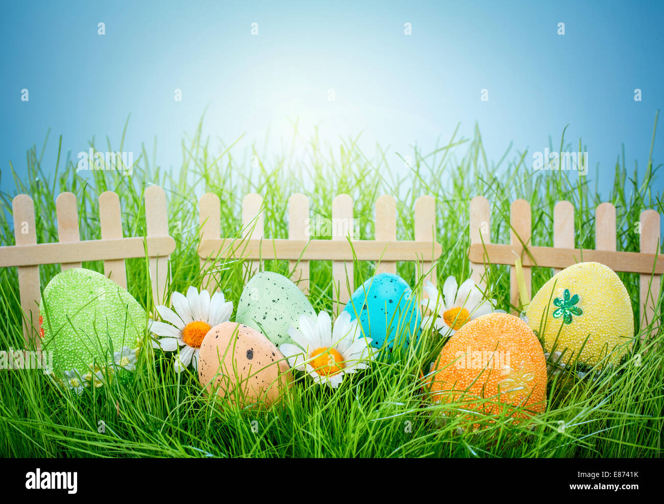 Decorated easter eggs in the grass on blue sky background Stock Photo ...