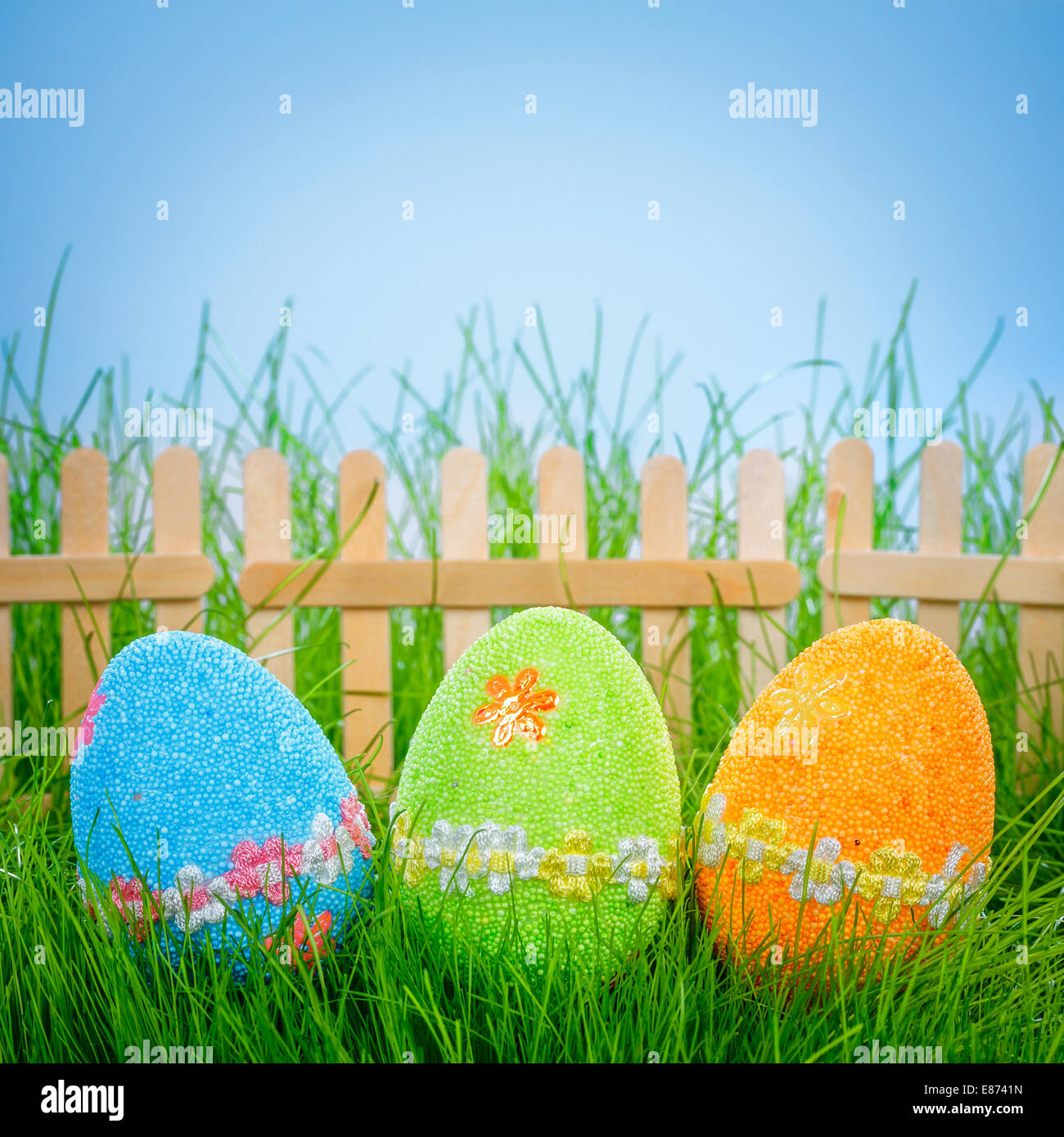 Decorated easter eggs in the grass on blue sky background Stock Photo ...