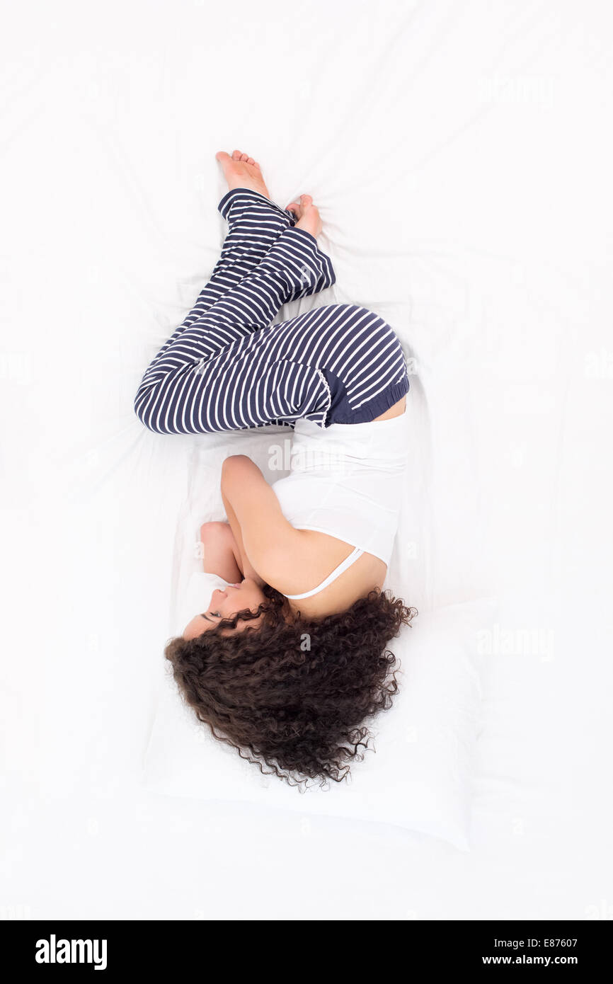 Female sleeping Foetus pose Stock Photo