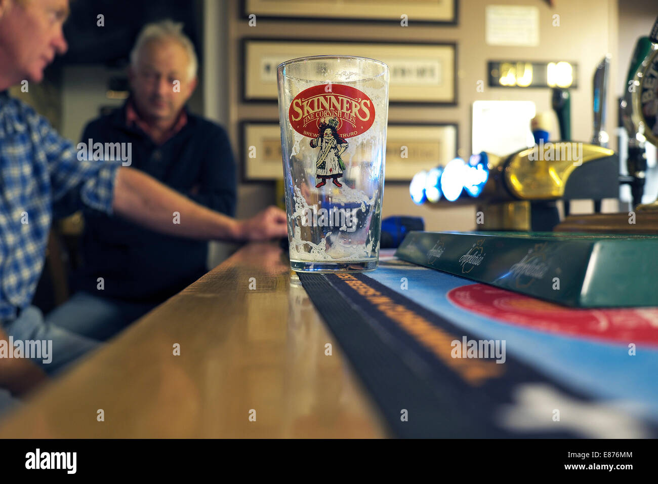 An empty pint glass on the bar of The Wink pub in Lamorna in Cornwall. Stock Photo