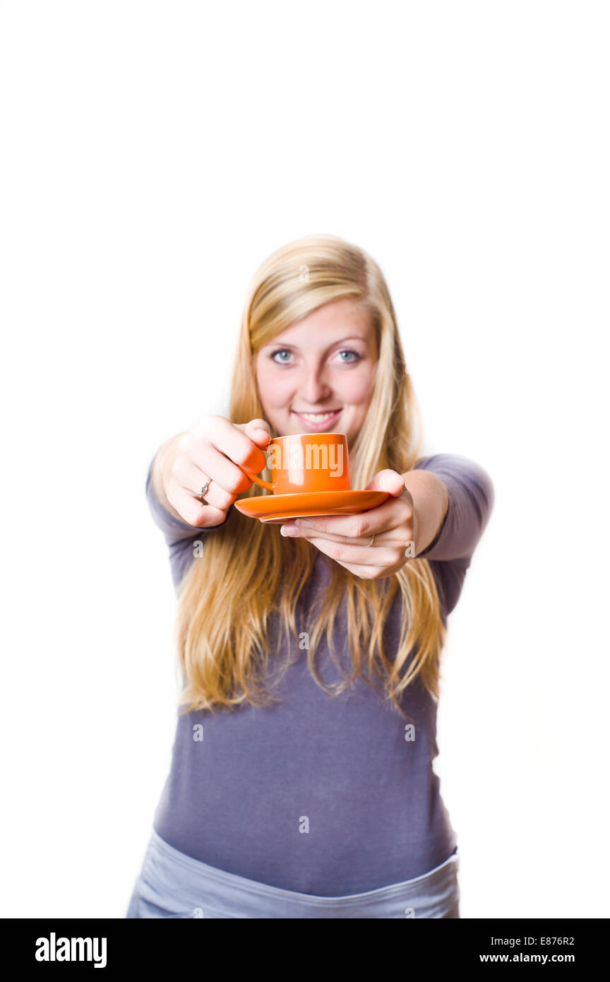 blond teenager girl smiling and offering a cup of coffee Stock Photo