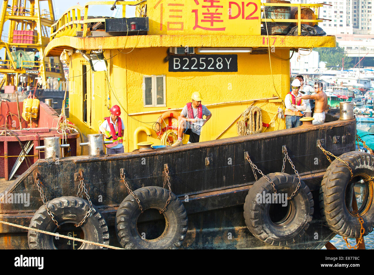 Team Of Engineers On The Deck Of A Derrick Barge In The Causeway Bay Typhoon Shelter, Hong Kong. Stock Photo