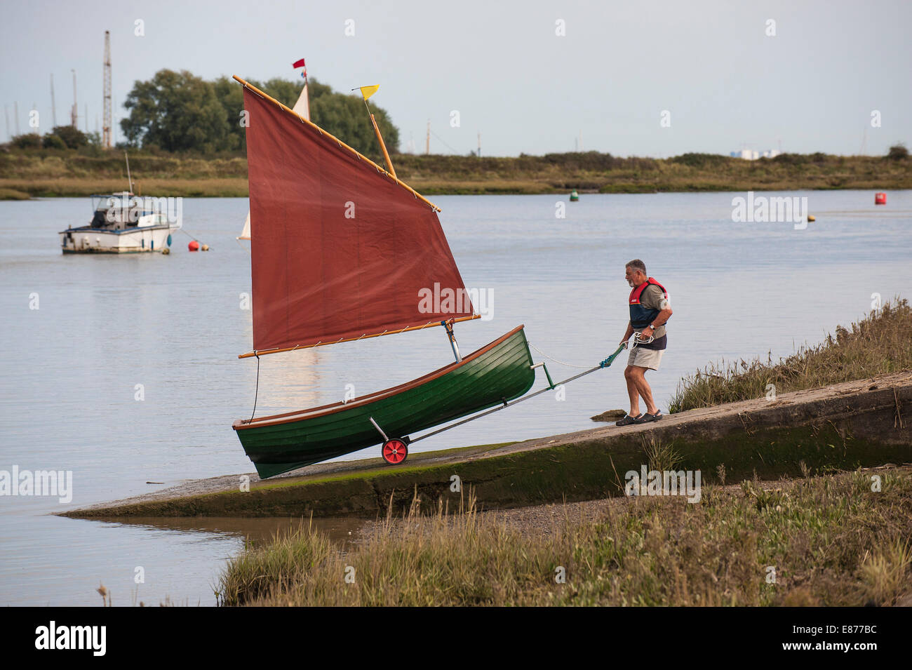 A man launching a Heybridge Roach on the Blackwater River in Essex. Stock Photo