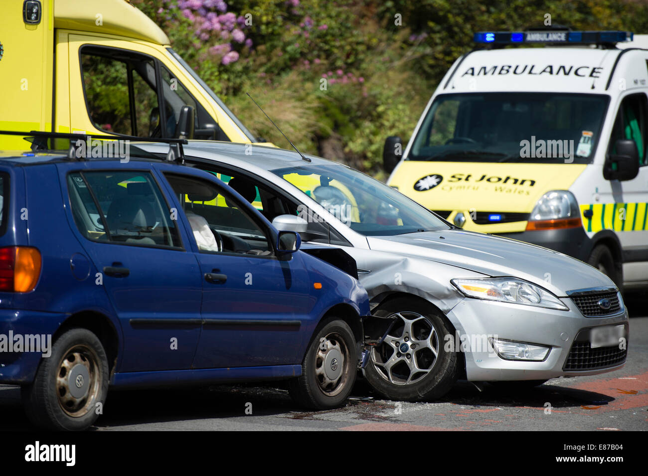 Two cars involved in a side impact road traffic accident collision, with ambulance in attendance UK Stock Photo