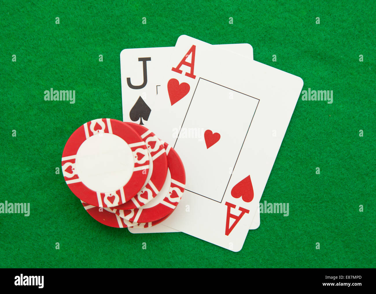 Blackjack hand with casino chip on green casino table Stock Photo