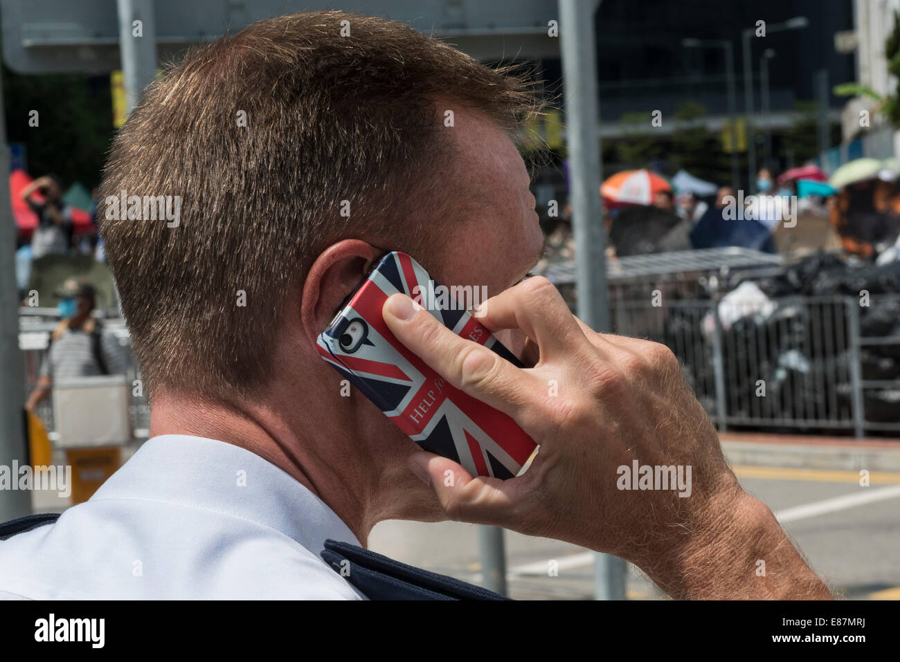 There are still some originally British policemen in the present Hong Kong police force, here with union jack phone Stock Photo
