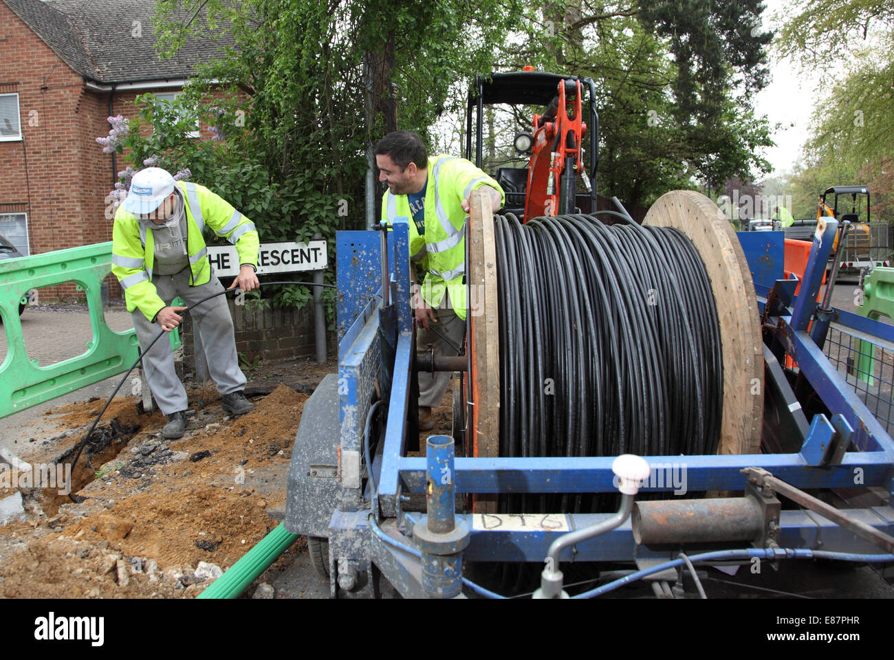 Workmen install new optical cables for high speed broadband in a rural street in southern England Stock Photo