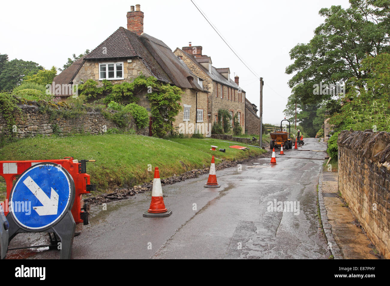 Cones divert traffic around works to install new fibre-optic broadband cables in a picturesque rural village in southern England Stock Photo