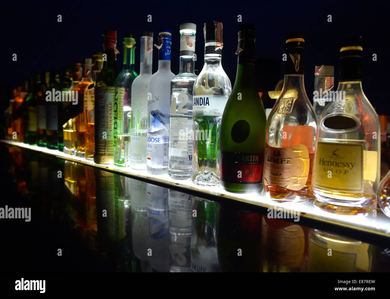 Bottles of various spirits in a row, reflected on a glass plate Stock Photo Alamy
