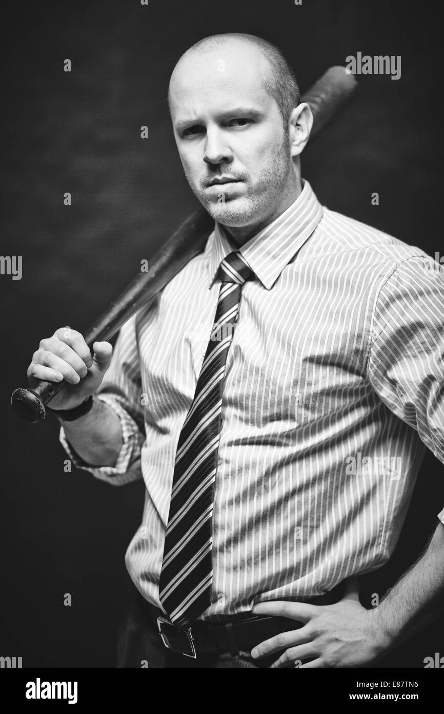 Dangerous businessman carrying baseball bat on his shoulder Stock Photo