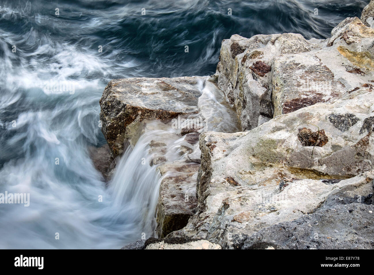 Closeup detail of the damage to the quay at Lamorna Cove in Cornwall. Stock Photo