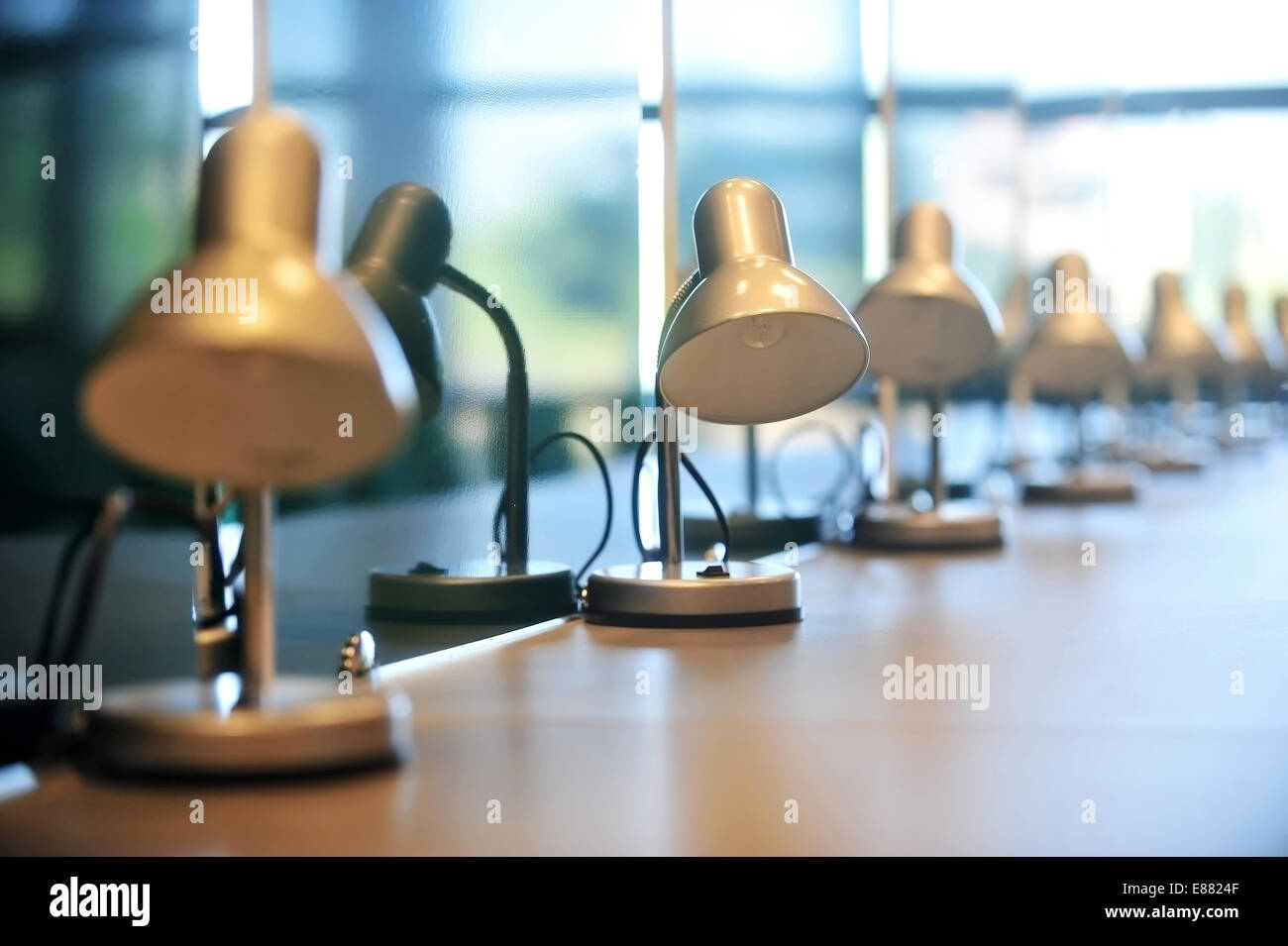 Several reading library lamps in a row on a desk Stock Photo