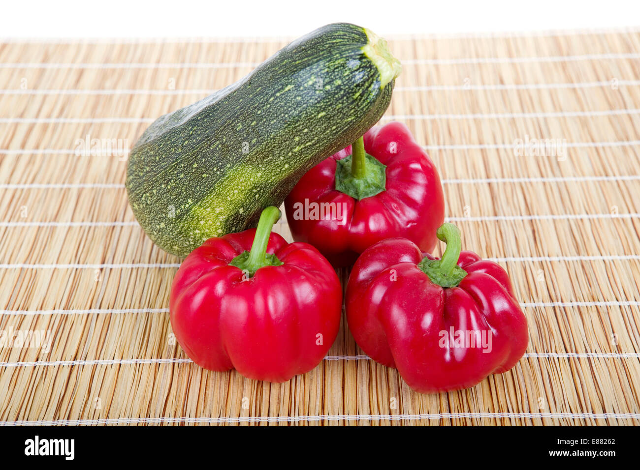 some peppers and a zucchini in a wooden table Stock Photo - Alamy