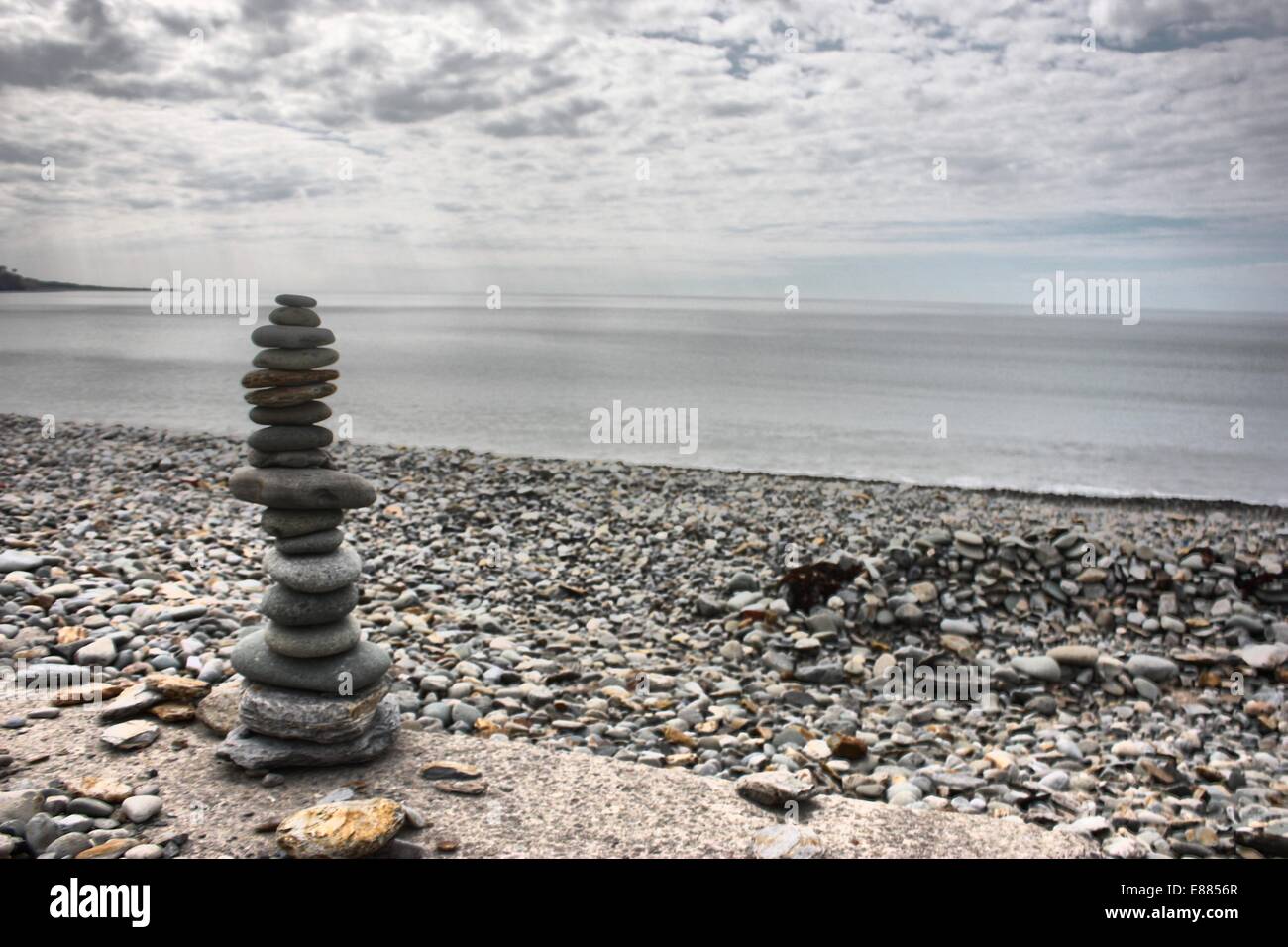 Man on beach balancing rocks hi-res stock photography and images - Alamy