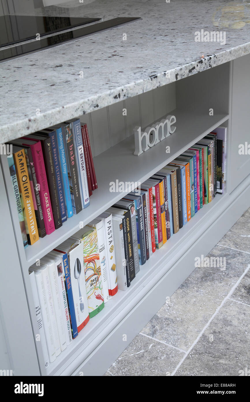 Bookshelf built into a kitchen island with a marble work-top. Stock Photo