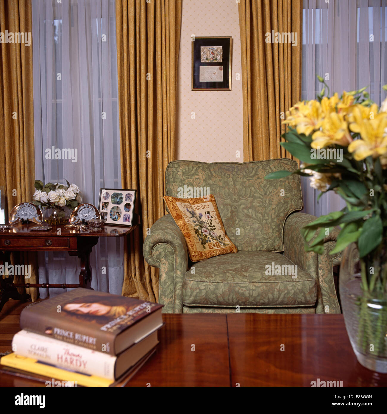 Green armchair and net curtains in archival living room Stock Photo
