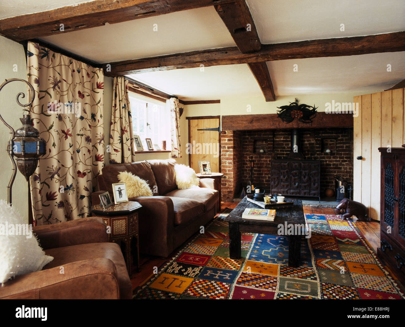 Leather Sofa And Armchair In Country Living Room With Hand Crafted Carpet And Crewelwork Curtains Stock Photo Alamy