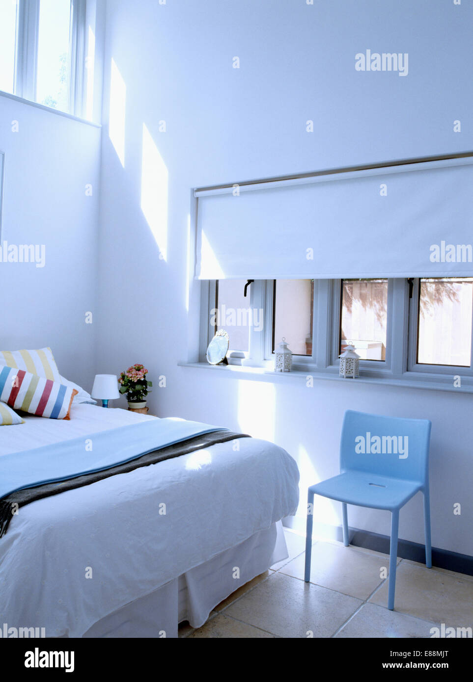 Jasper Morrison blue Air" chair below windows with white blind in