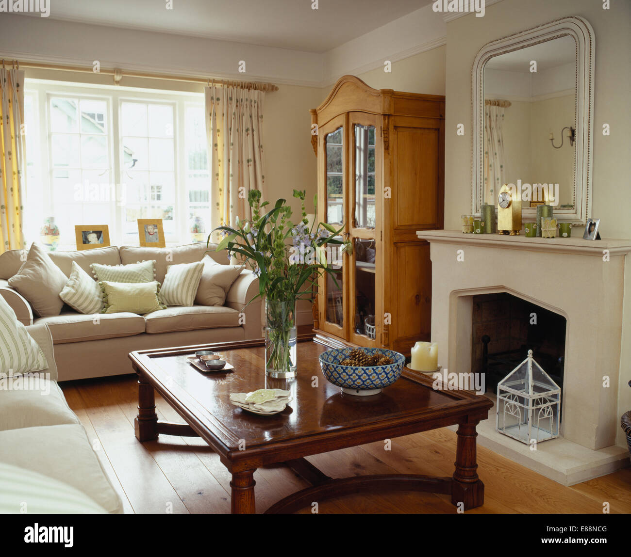 Indonesian Wood Coffee Table In Front Of Fireplace In Living Room With Cream Sofas And Glass Fronted Pine Cupboard Stock Photo Alamy