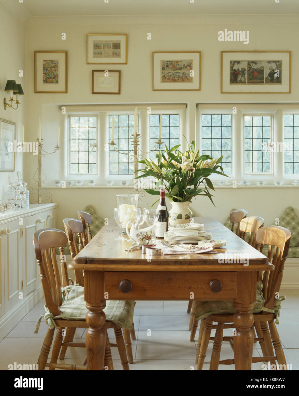 Antique pine table and chairs in neutral country dining room Stock