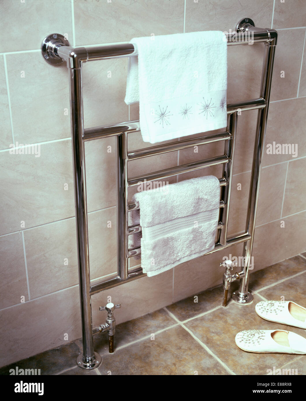 Closeup of chrome heated towelrail with white towels Stock Photo Alamy