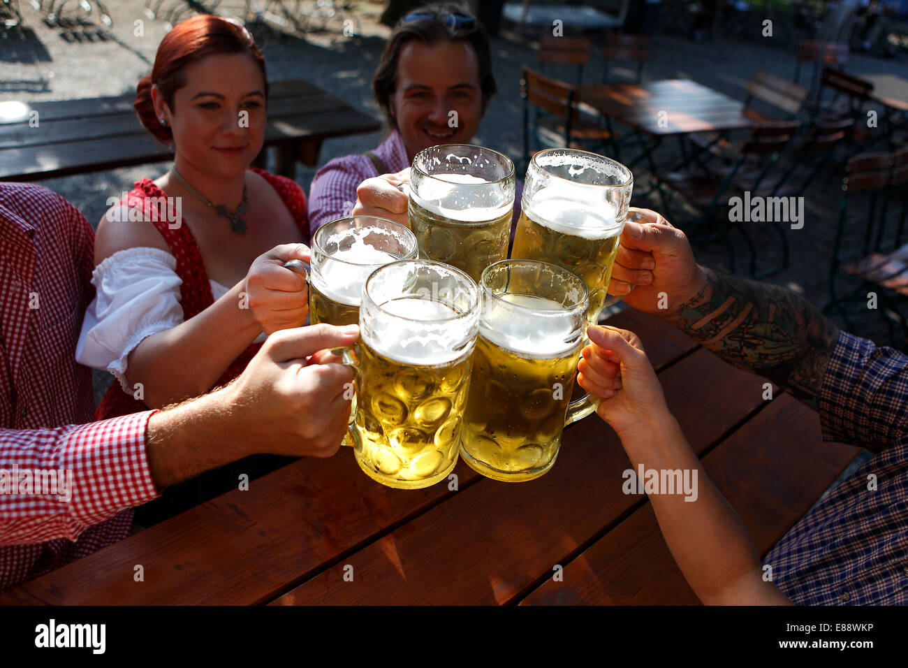 People in traditional costumes drinking beer in a Bavarian beer garden Stock Photo