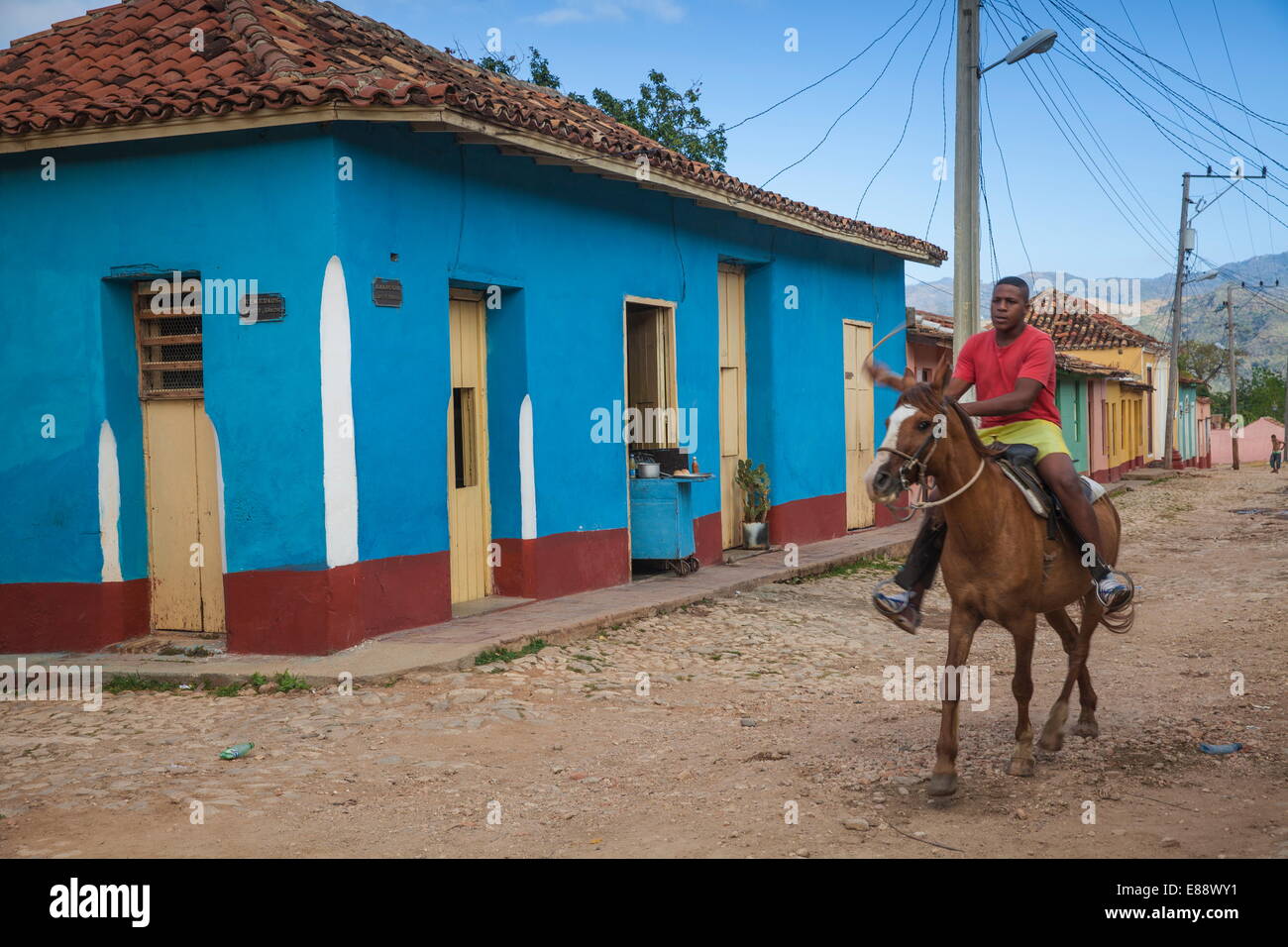 Man riding horse along cobbled street in historical center, Trinidad, Sancti Spiritus Province, Cuba, West Indies, Caribbean Stock Photo