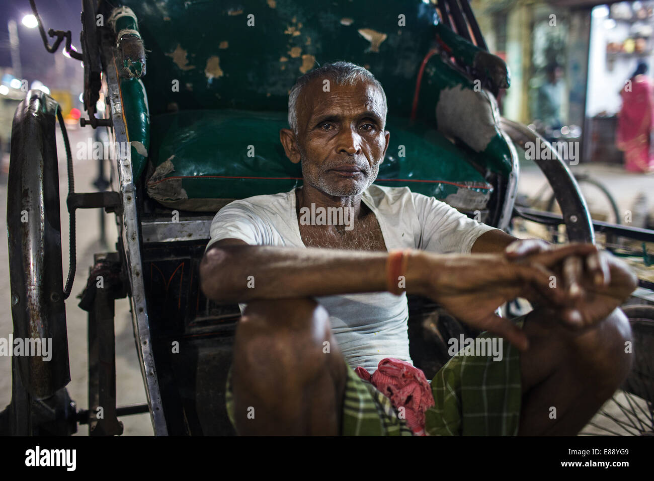 A night portrait of a rickshaw puller in Kolkata, India Stock Photo