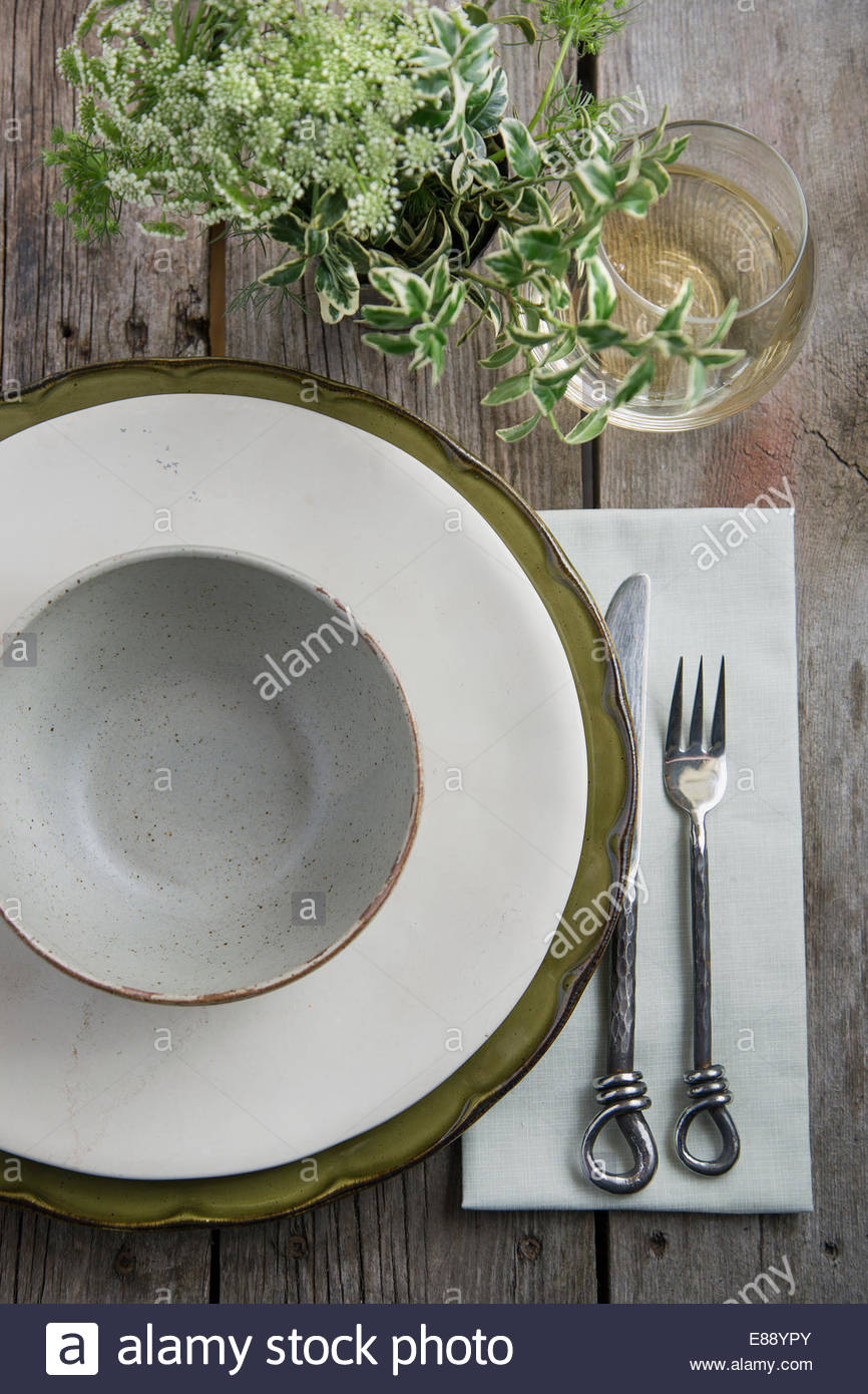 Place setting and wine on rustic wood table Stock Photo