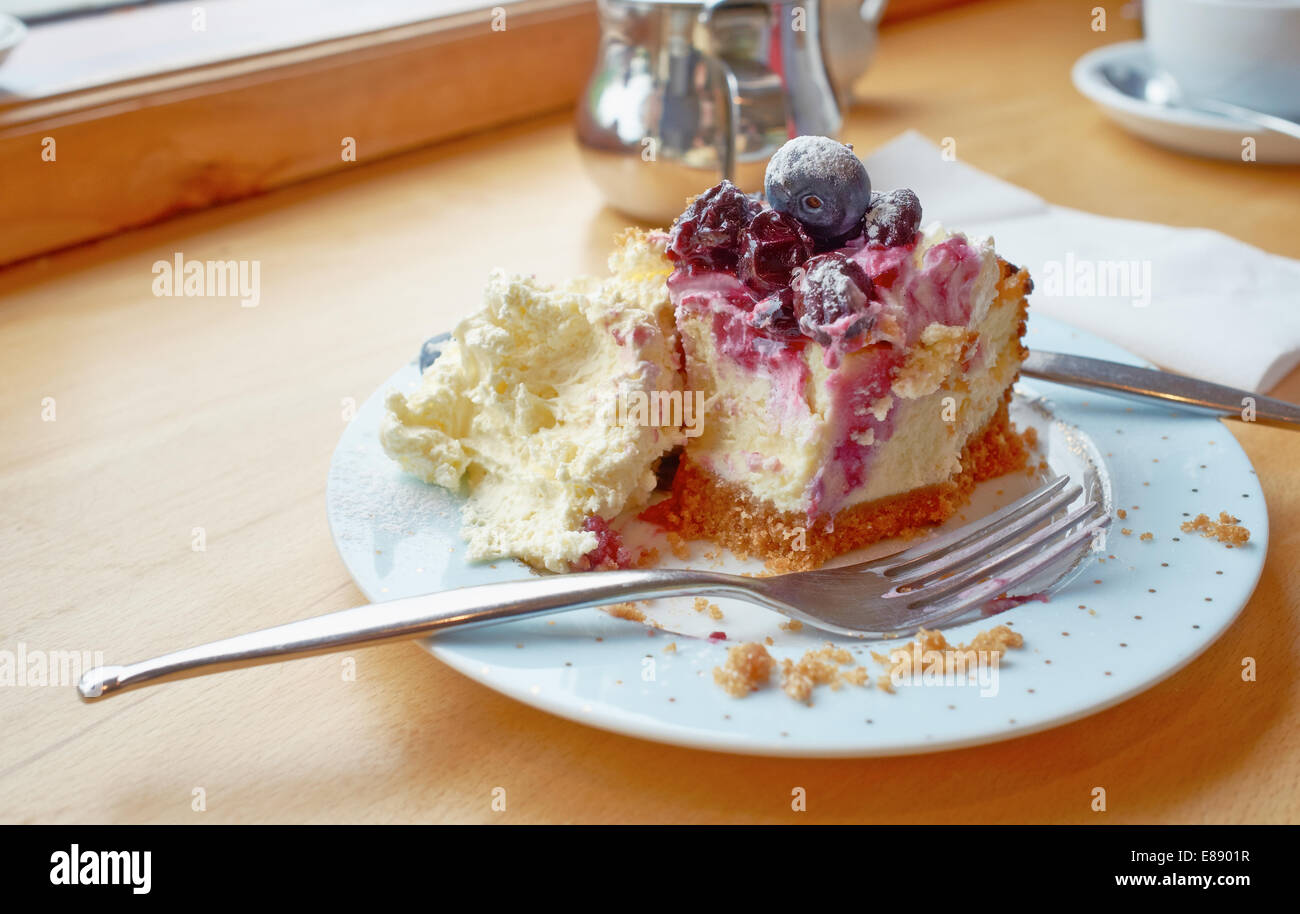 A luxurious Blueberry Cheesecake with a large helping of clotted cream. Stock Photo