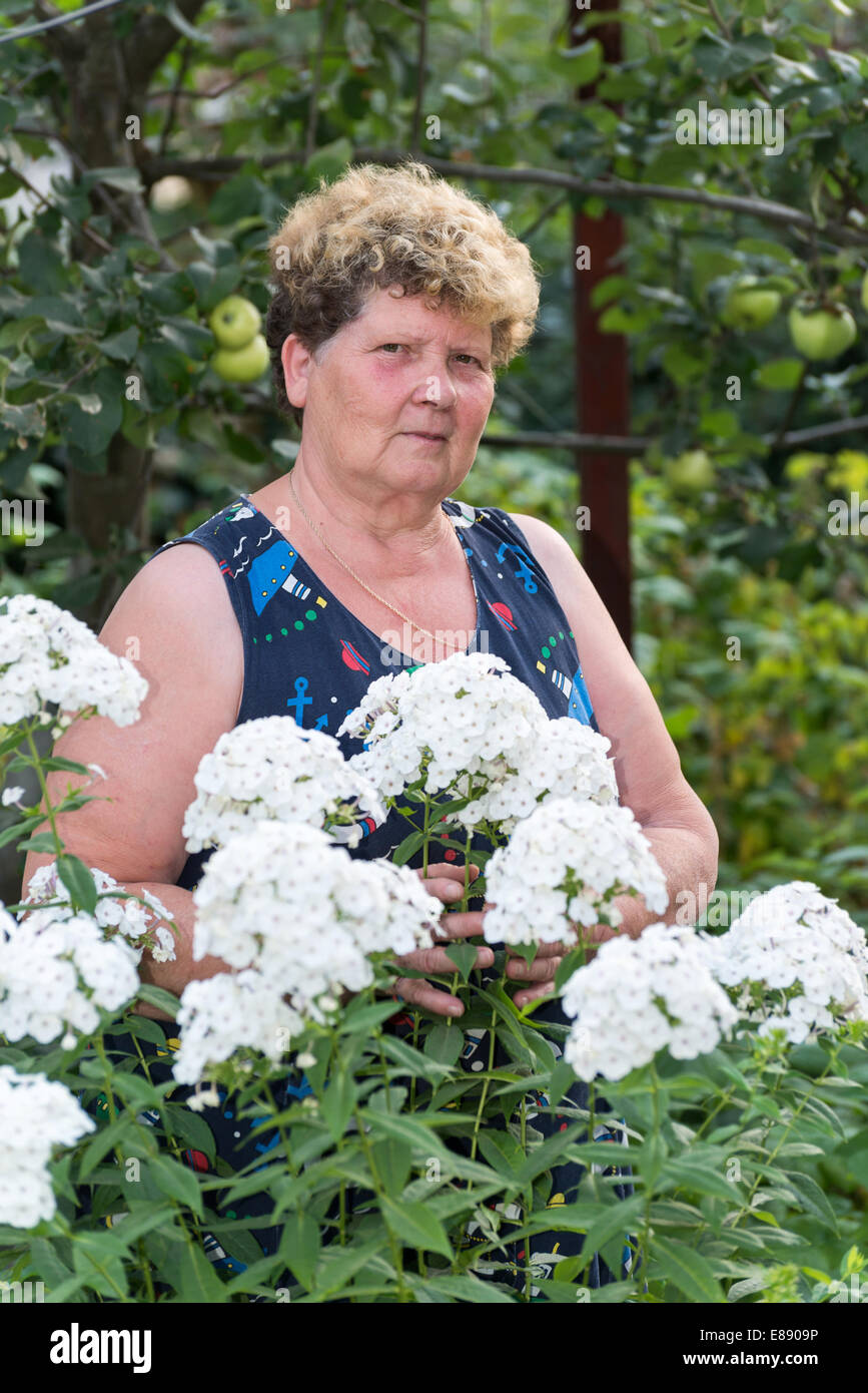 mature woman with flowers at garden Stock Photo - Alamy