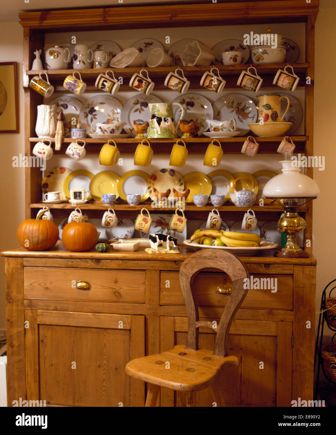 Wooden Chair In Front Of Old Pine Dresser With Collection Of China