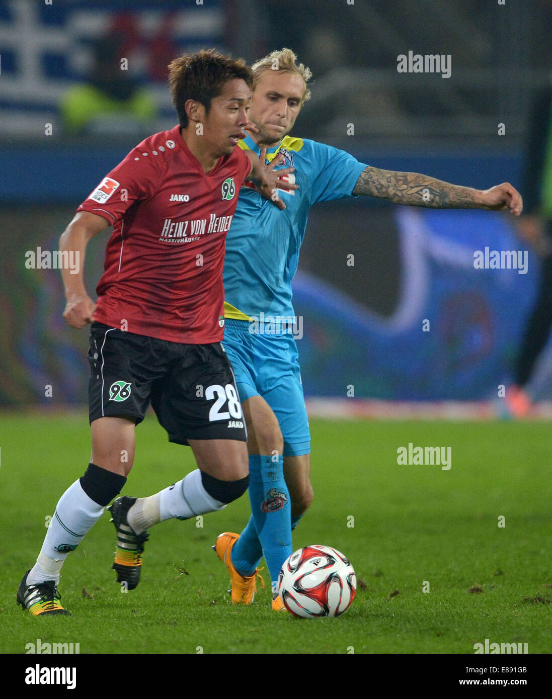 Hannover's Hiroshi Kiyotake and Koln's Marcel Risse fight for the ball at the Bundesliga game between Hannover 96 and FC Koln in the HDI Arena in Hanover, Germany, 24 September, 2014. Photo: Peter Steffen/dpa Stock Photo