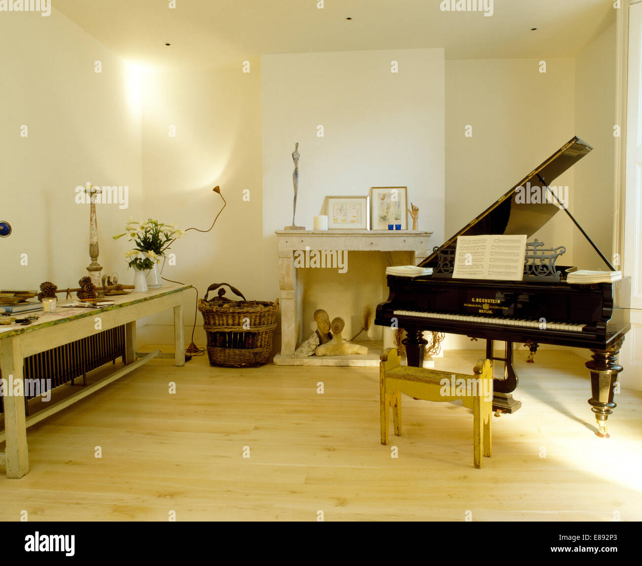 Grand piano and wooden flooring in music room with painted dining rable