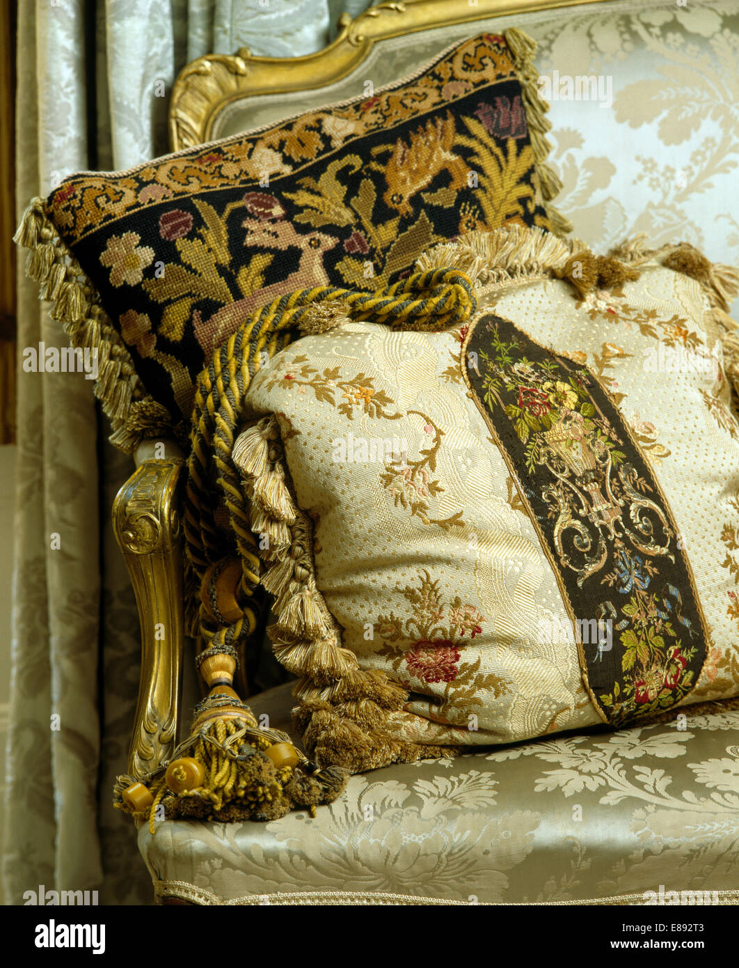 Close-up of Jacobean style tapestry and floral cushions edged with rich braid and tassels Stock Photo
