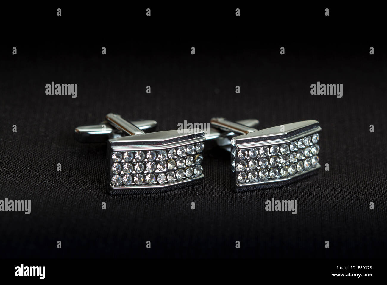 Pair of silver cuff links over black background Stock Photo