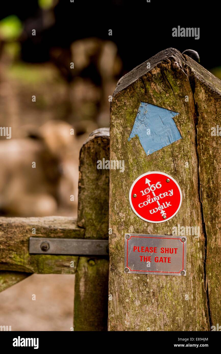 A gateway on the 1066 country walk route showing the logo and a blue arrow. Stock Photo