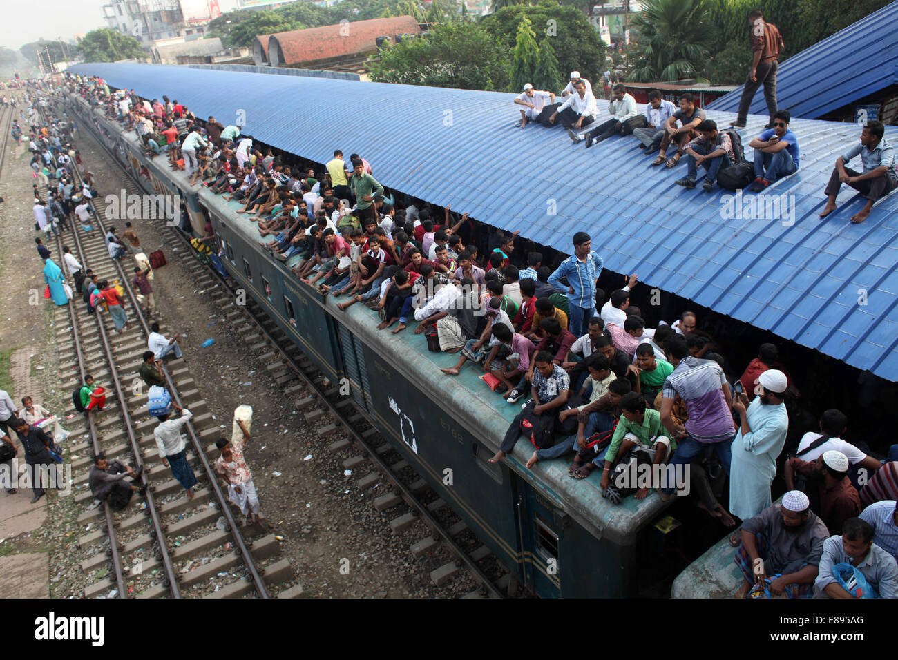 Dhaka, Bangladesh. 2nd Oct, 2014. Crowds of people board the roofs of trains in Dhaka, Bangladesh, for a risky ride to their home villages. Millions of city dwellers return home for Eid al-Adha. Credit:  Zakir Hossain Chowdhury/ZUMA Wire/Alamy Live News Stock Photo