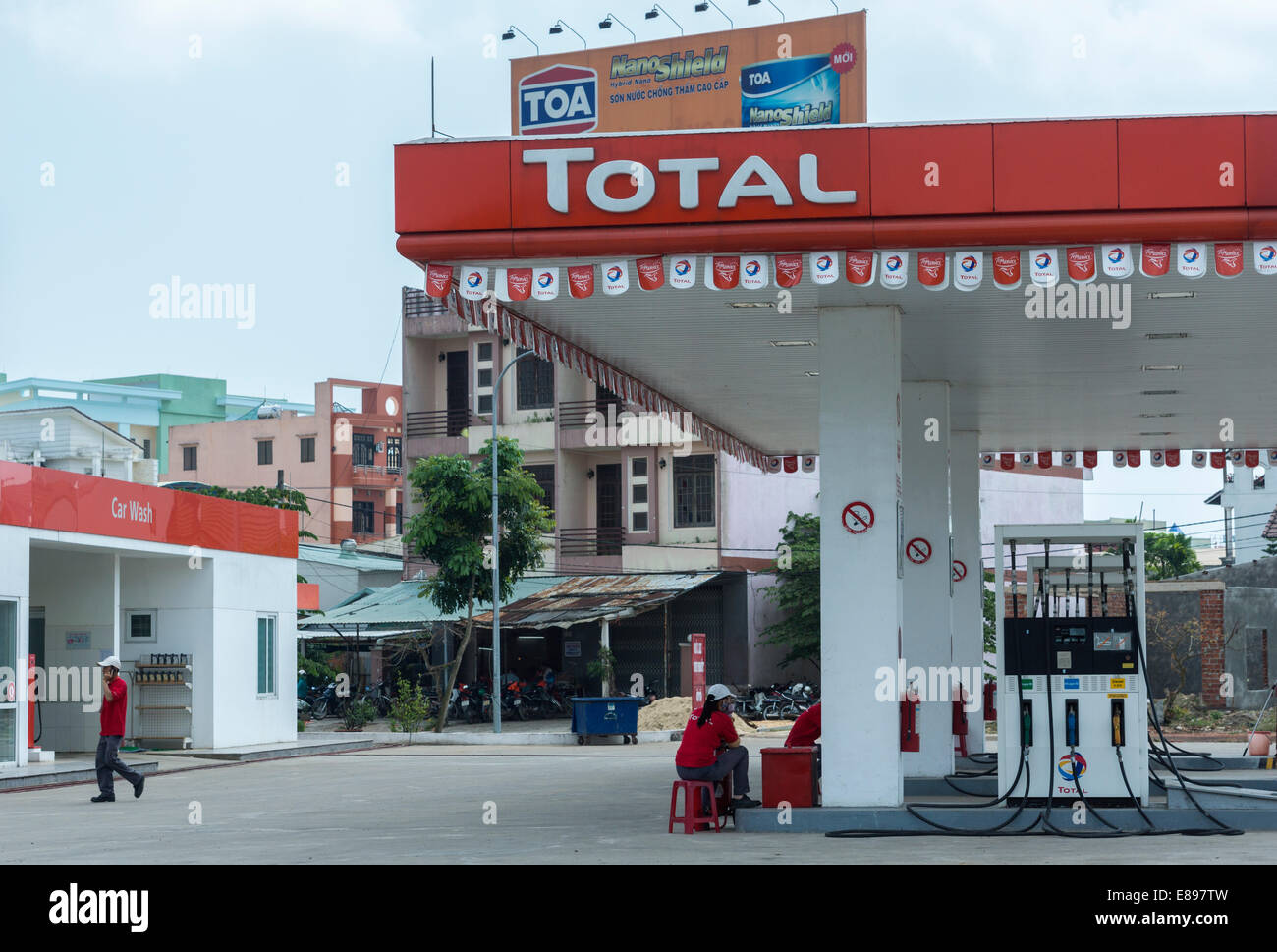 Attendants wait for customers at Total gas station. Stock Photo
