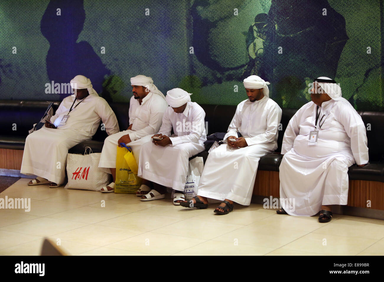 Dubai, United Arab Emirates, men in national dress sitting on a bench Stock Photo